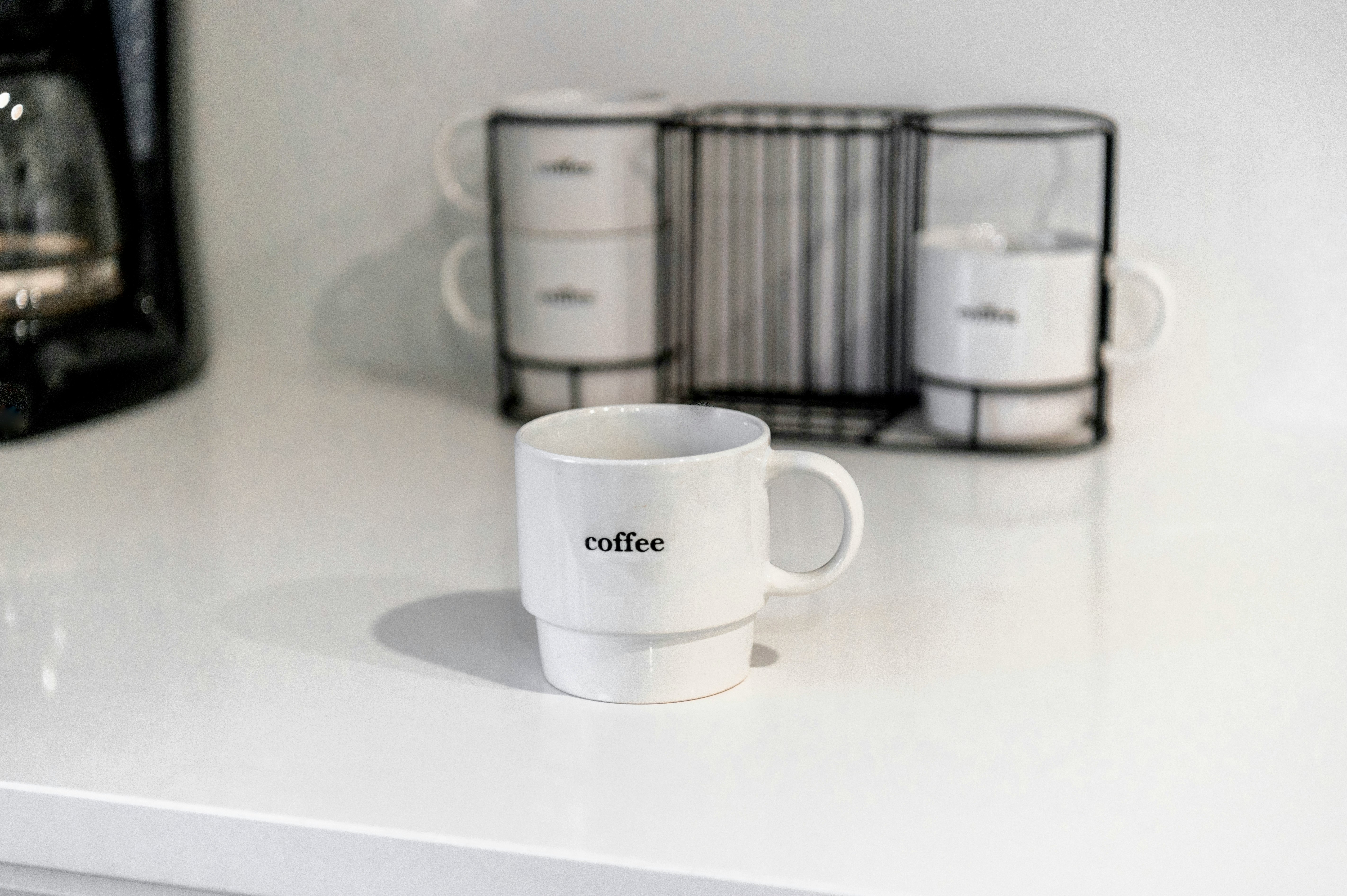 white ceramic mug on white table